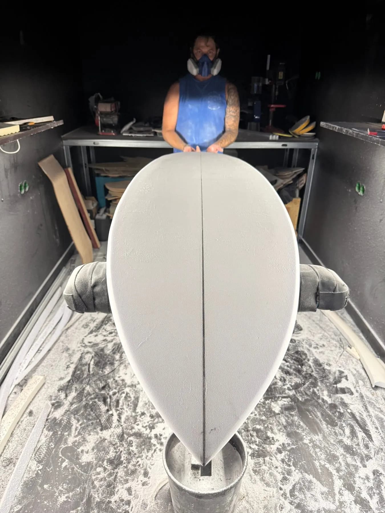 Surfboard shaper hand-finishing a custom board at Fajã Surf Labs, São Vicente, Madeira